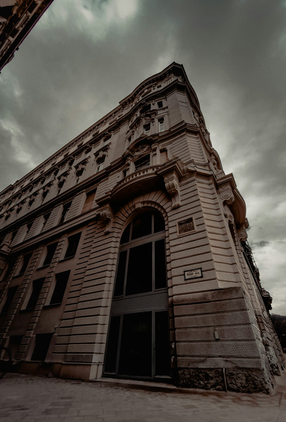 low angle photography of brown concrete building under cloudy sky during daytime