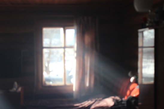 a serene photograph of morning light filtering through a window onto a simple, cozy interior scene