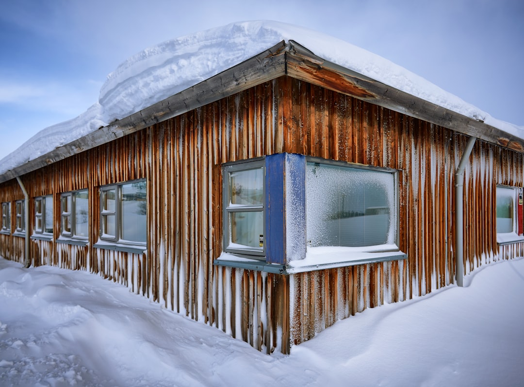 brown wooden house covered with snow during daytime