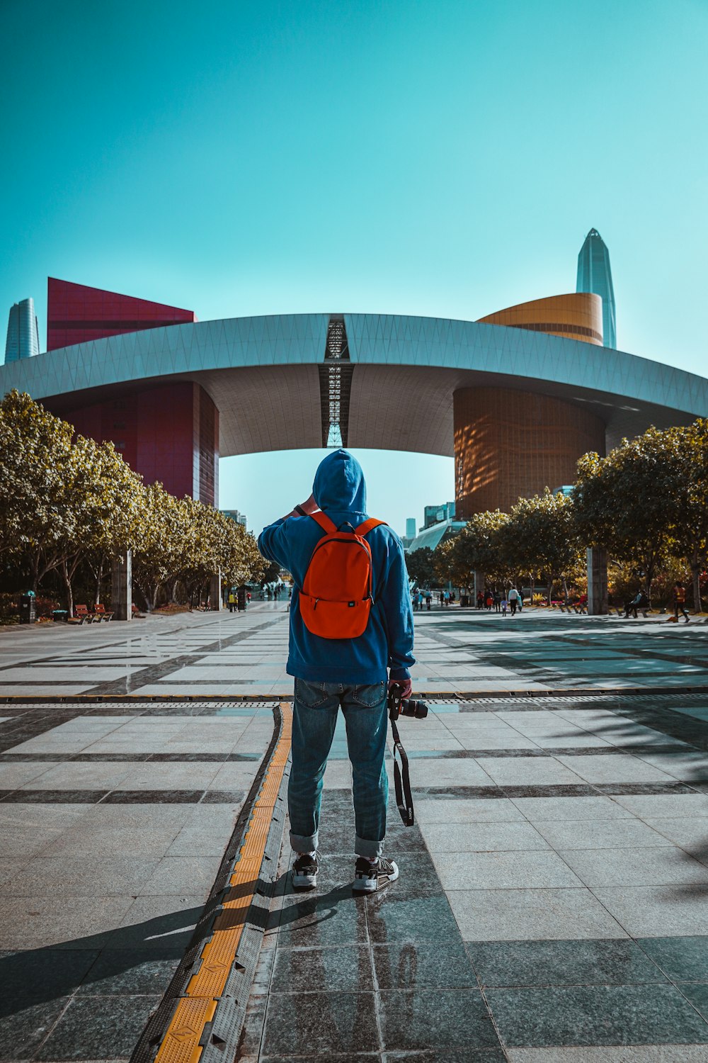 man in blue jacket and black pants walking on pedestrian lane during daytime