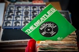 Vintage Beatles vinyl records stacked with classic album covers visible.