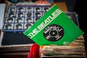 A vintage vinyl record featuring the Beatles, surrounded by musical notes.