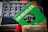A collection of vinyl records is shown, with one prominently featuring a green cover labeled 'THE BEATLES' and a black vinyl disk in the center with additional text and graphics. The background includes blurred images of other albums with portraits of people.