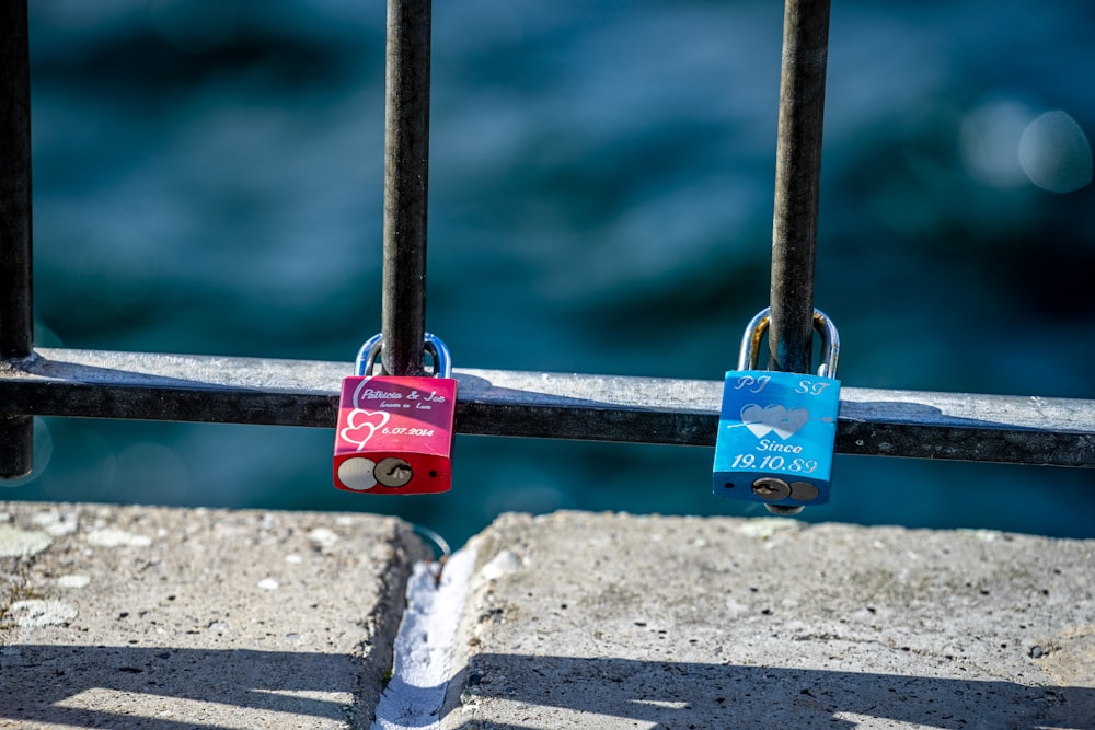 blue and red padlock on grey metal fence