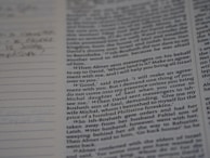 A close-up of a Bible page showing text in two columns. The words are clear and readable, including specific references to biblical names and events. There are some lined notes on the left side, indicating personal annotations or additional commentary.