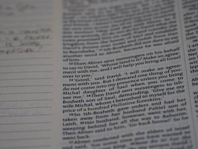 A close-up of a Bible page showing text in two columns. The words are clear and readable, including specific references to biblical names and events. There are some lined notes on the left side, indicating personal annotations or additional commentary.