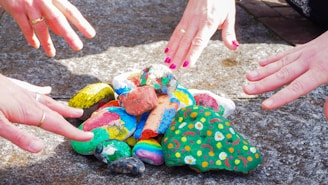 person holding blue and yellow heart shaped ornament