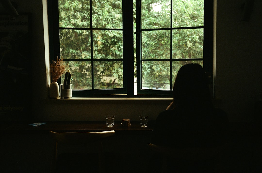 silhouette of person sitting on chair near window