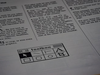 A printed page of text is visible, featuring instructions and explanations related to drawing tools and text editing. In the bottom section of the page, there is a graphic of a toolbox with various tool icons including a text tool and shape tools.