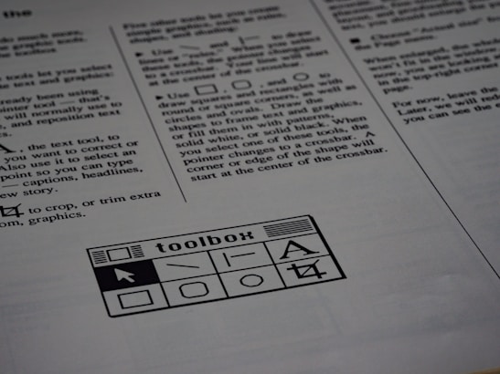 A printed page of text is visible, featuring instructions and explanations related to drawing tools and text editing. In the bottom section of the page, there is a graphic of a toolbox with various tool icons including a text tool and shape tools.