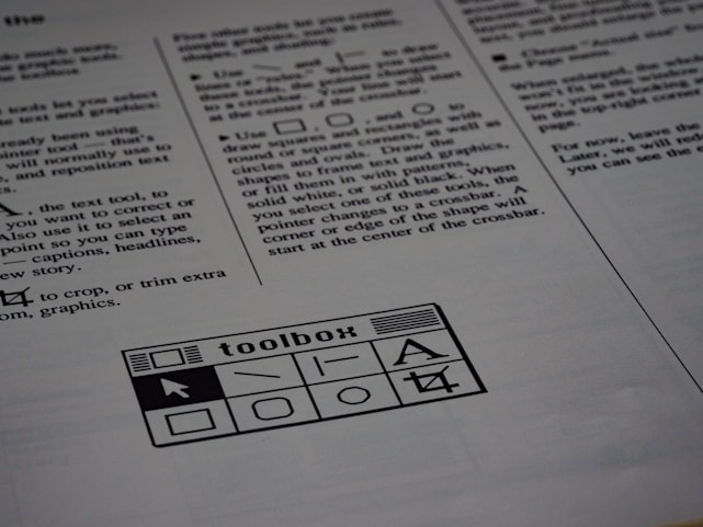A printed page of text is visible, featuring instructions and explanations related to drawing tools and text editing. In the bottom section of the page, there is a graphic of a toolbox with various tool icons including a text tool and shape tools.