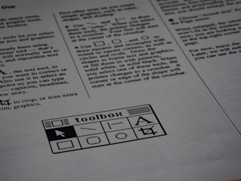 A printed page of text is visible, featuring instructions and explanations related to drawing tools and text editing. In the bottom section of the page, there is a graphic of a toolbox with various tool icons including a text tool and shape tools.