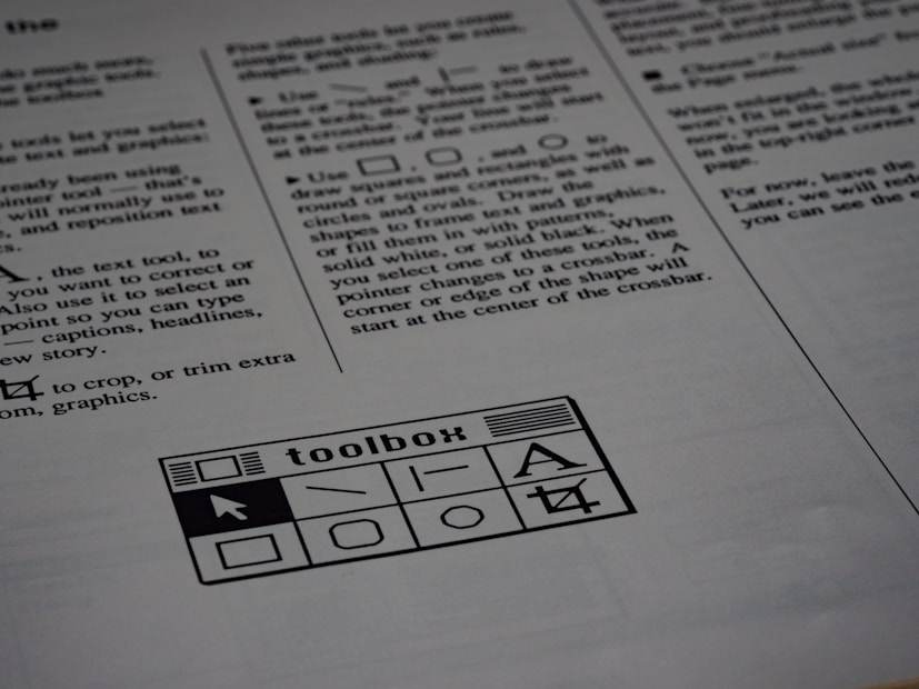 A printed page of text is visible, featuring instructions and explanations related to drawing tools and text editing. In the bottom section of the page, there is a graphic of a toolbox with various tool icons including a text tool and shape tools.