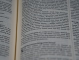 A close-up image of an open book displaying paragraphs of text in a serif font. The text appears to be from a narrative, focusing on a biblical or historical story. The pages are slightly curved, suggesting the book is being held open or resting.