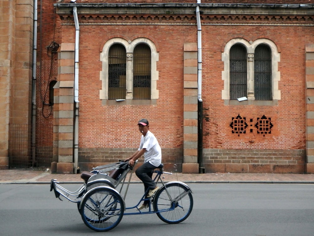 man in white dress shirt riding on black bicycle during daytime