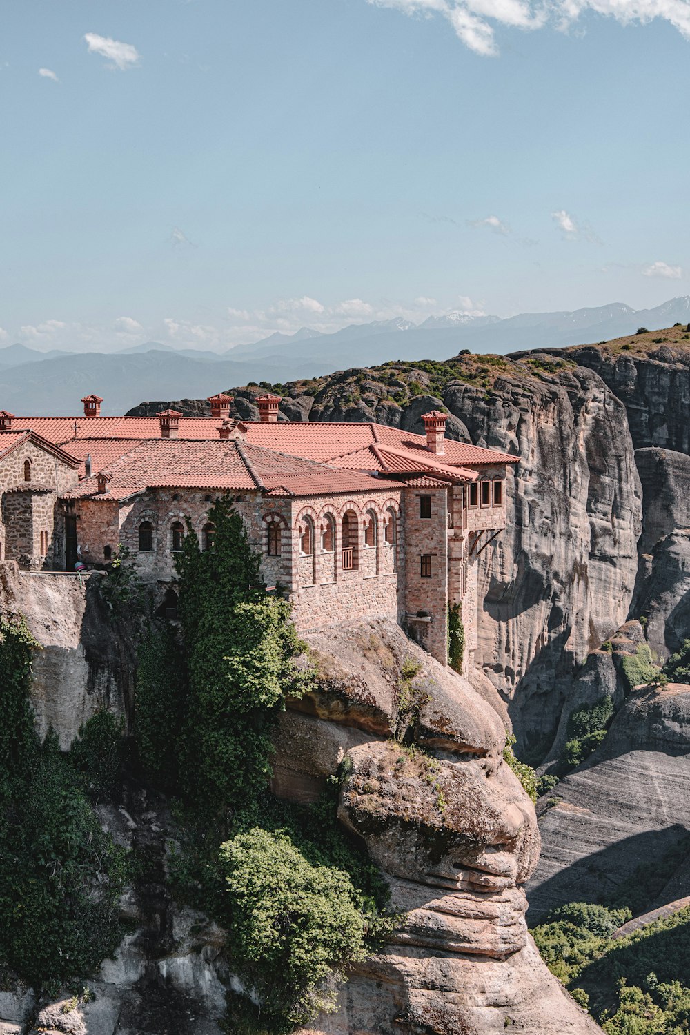 brown and white concrete building on cliff