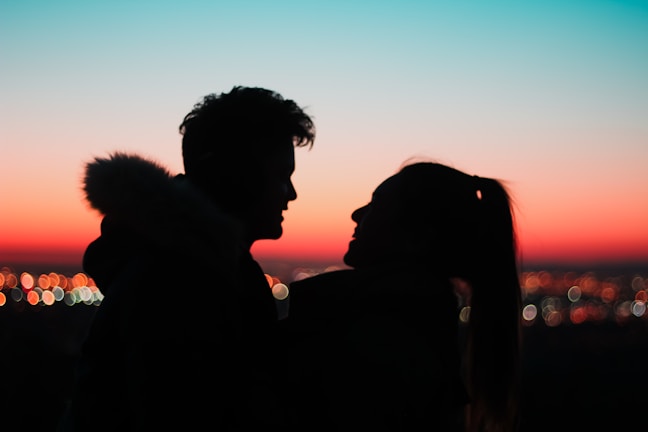 Silhouetted couple against the deep charcoal evening sky, with Jaipur’s historic skyline in the background.