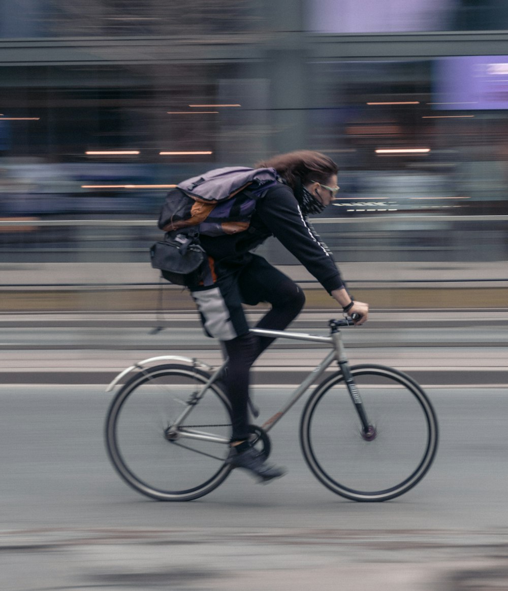 自転車に乗っている黒いジャケットの女性