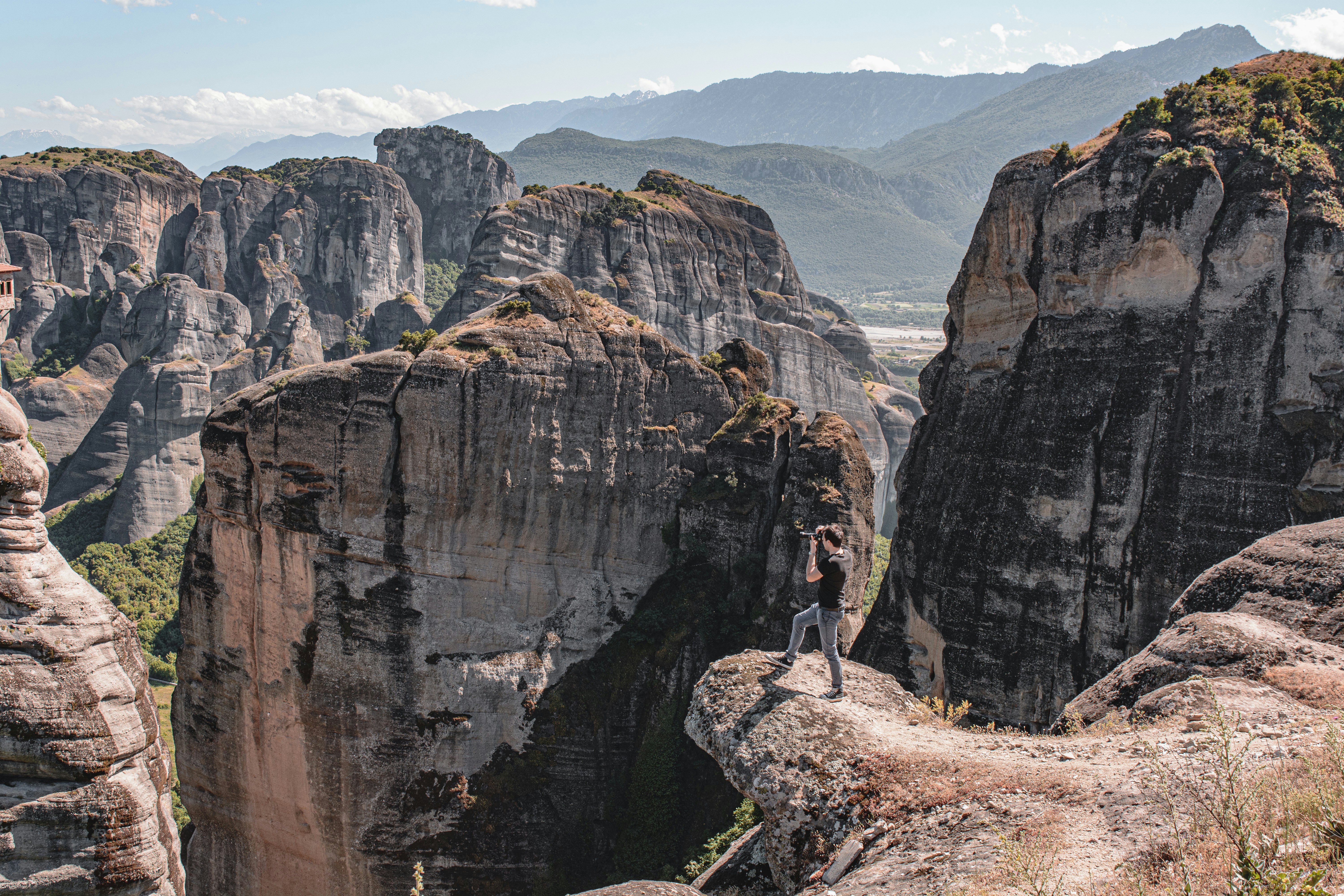 person in black jacket standing on rock formation during daytime