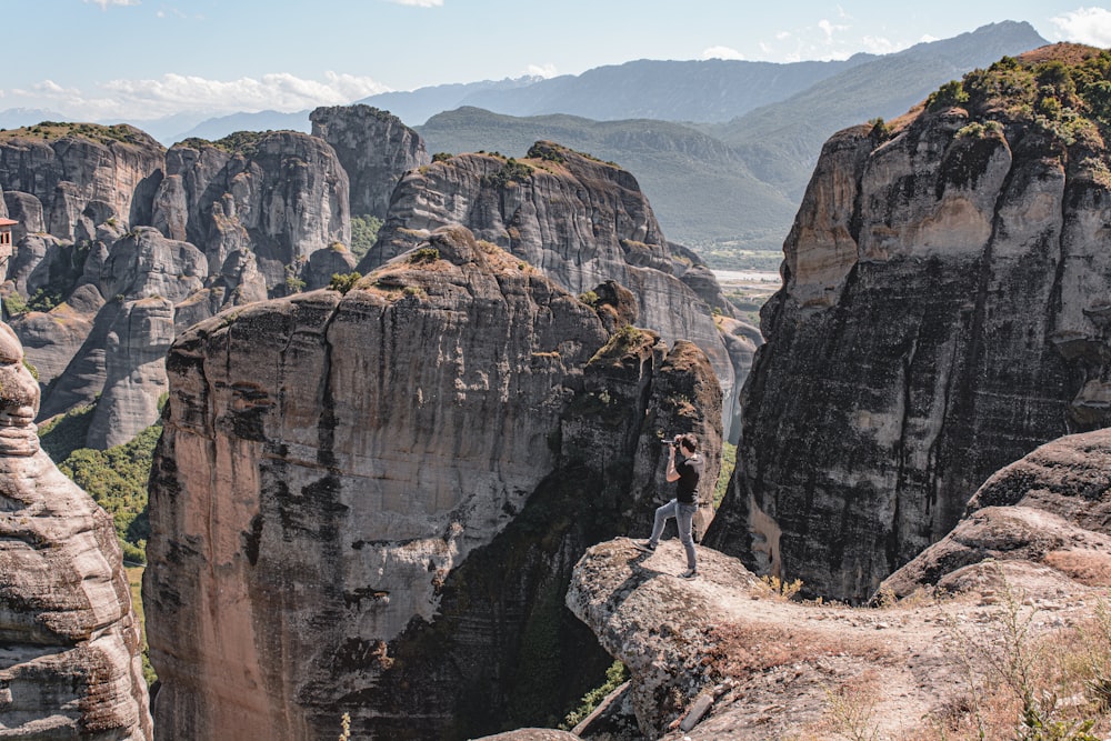 person in black jacket standing on rock formation during daytime