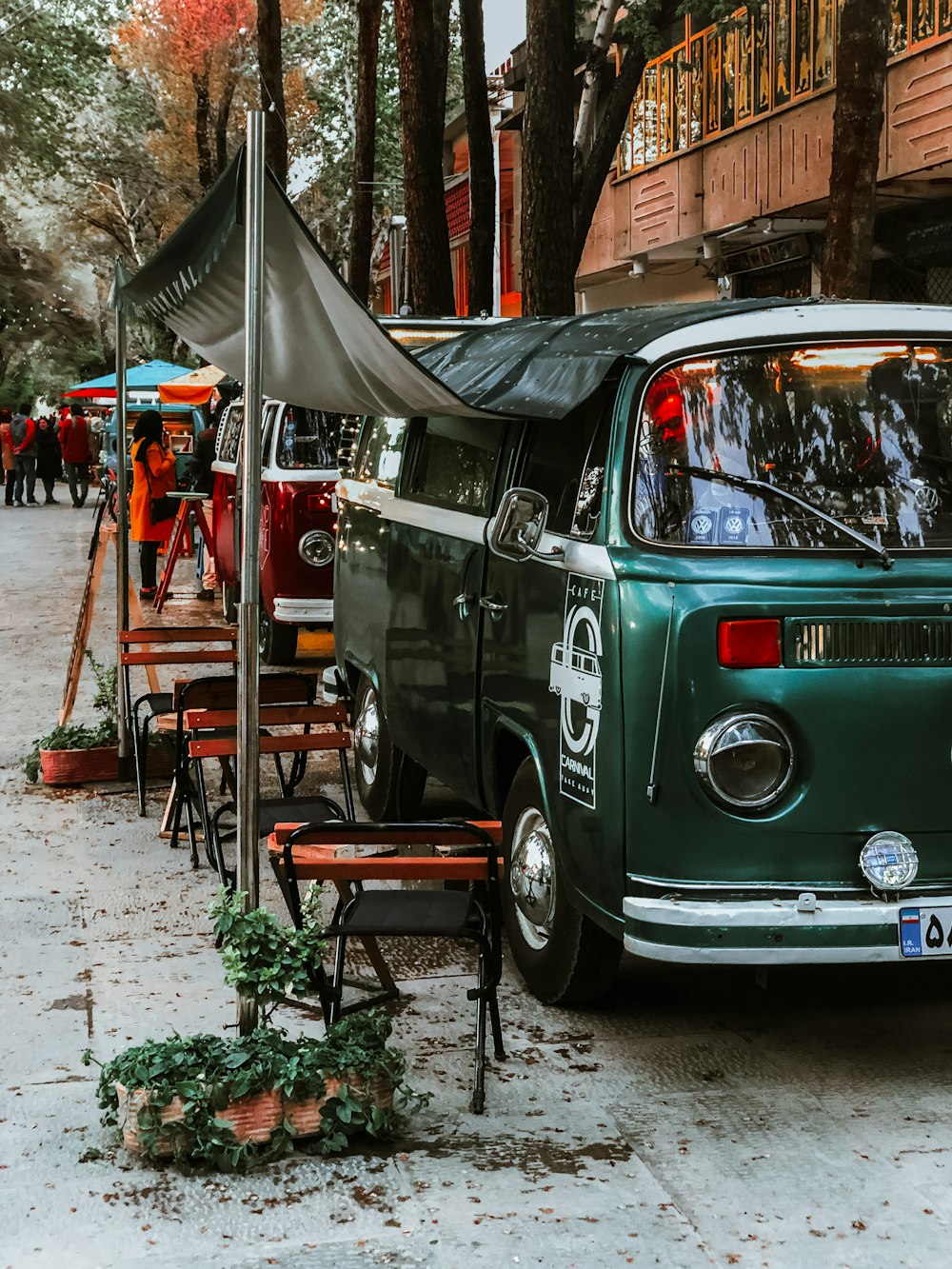 teal volkswagen t-2 parked near red metal frame