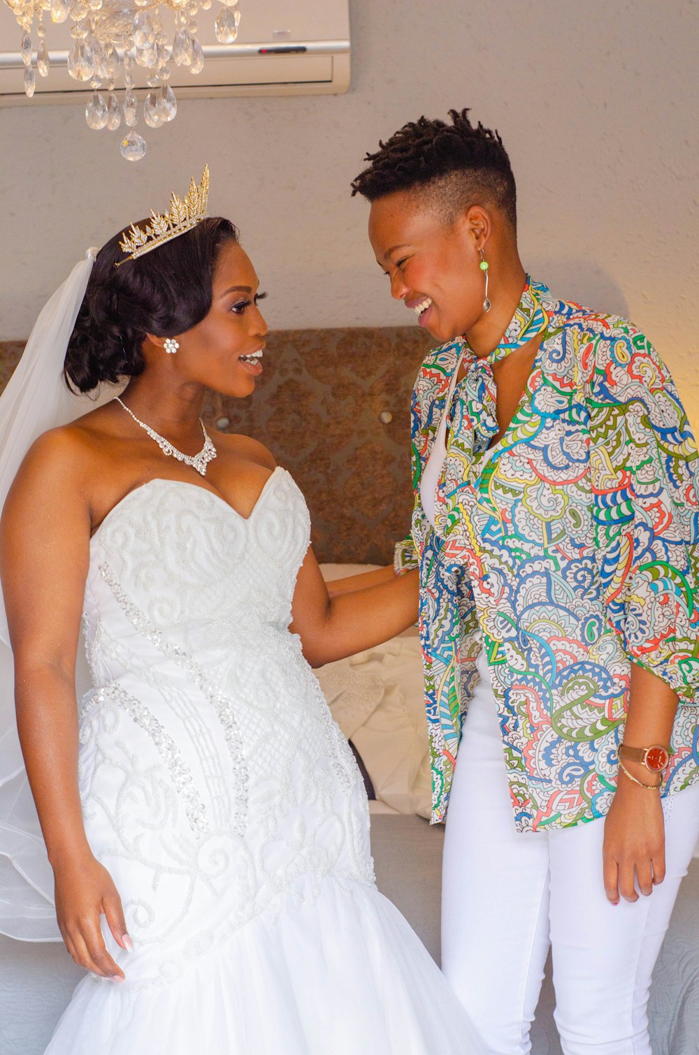 woman in white wedding gown beside man in red blue and yellow floral button up shirt