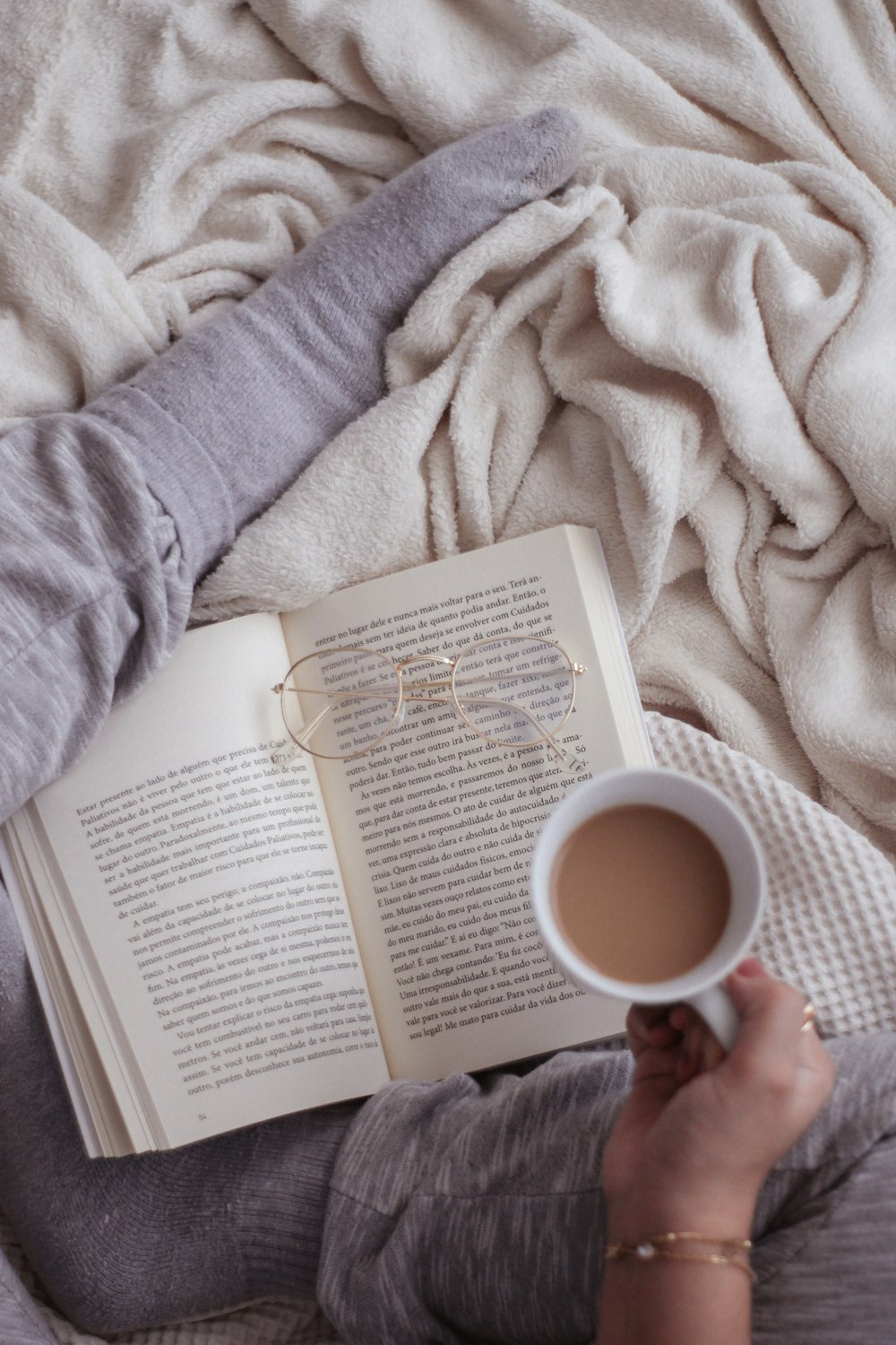 person in gray sweater reading book