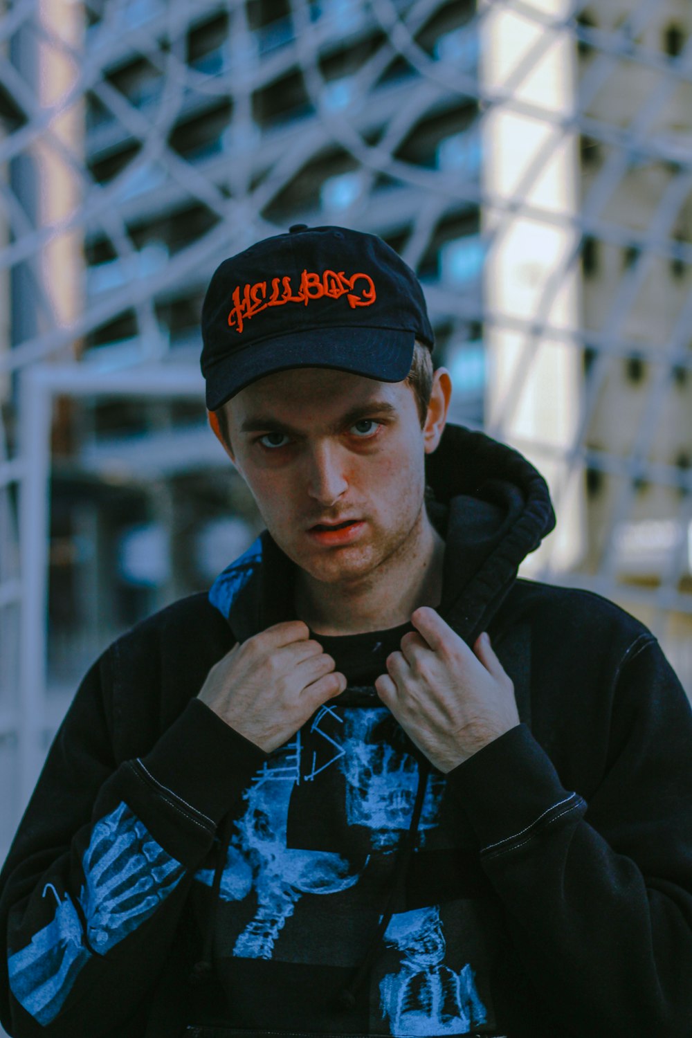 man in black and blue hoodie wearing black cap