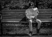 grayscale photo of woman sitting on bench