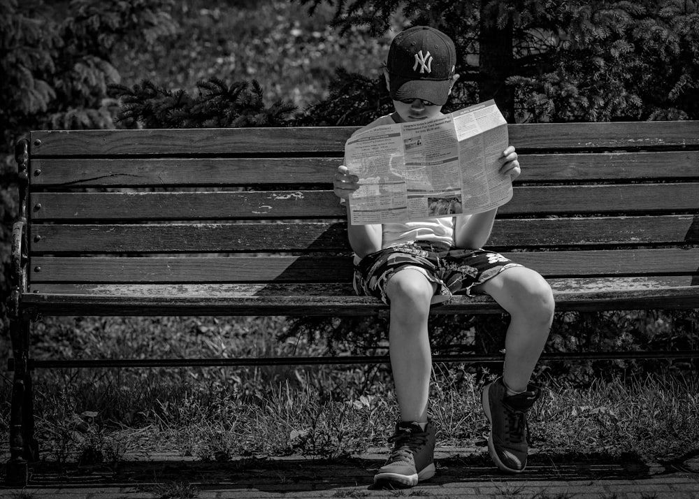 grayscale photo of woman sitting on bench