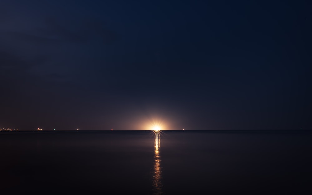 light post on the sea during night time