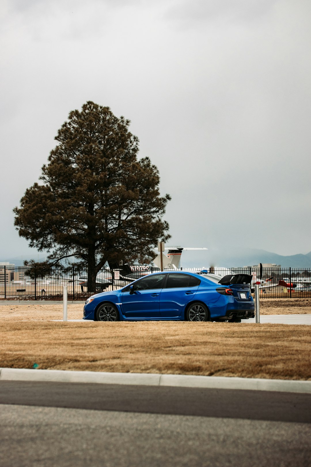 blue coupe on brown field during daytime