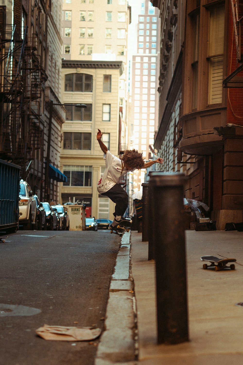 Homme en chemise à manches longues blanche et jean en denim bleu sautant sur le trottoir pendant la journée