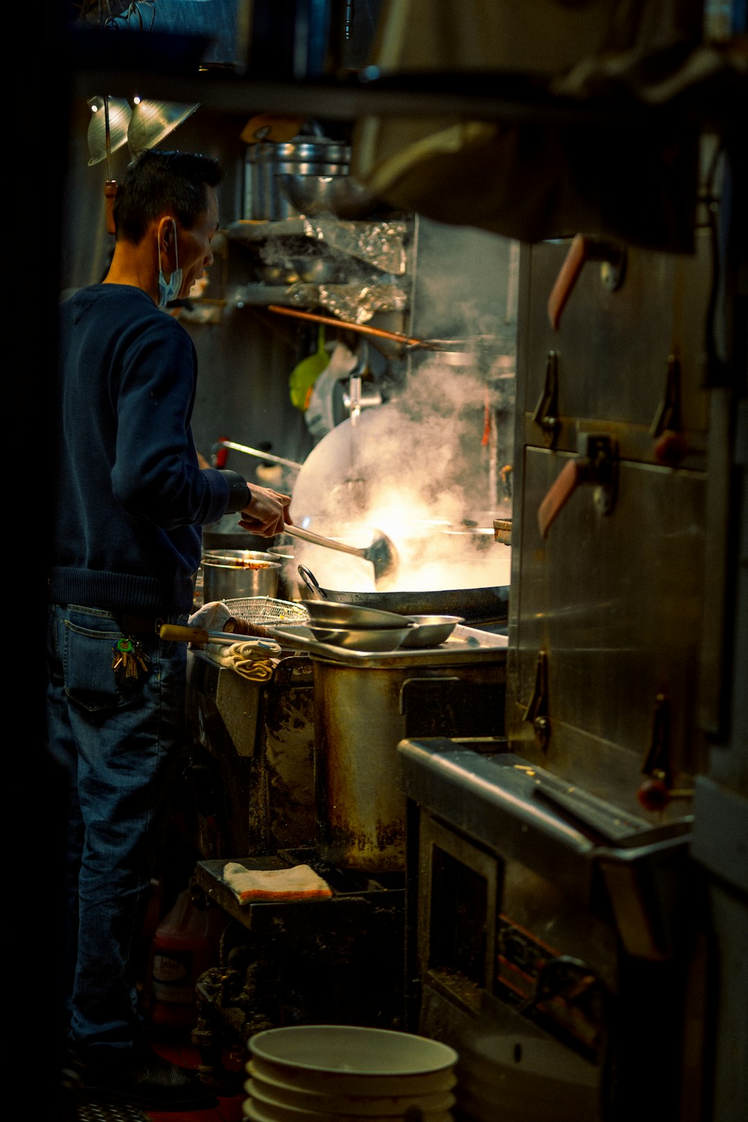 man in blue jacket cooking