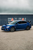 A sleek Japanese car being carefully loaded onto a shipping container for export.