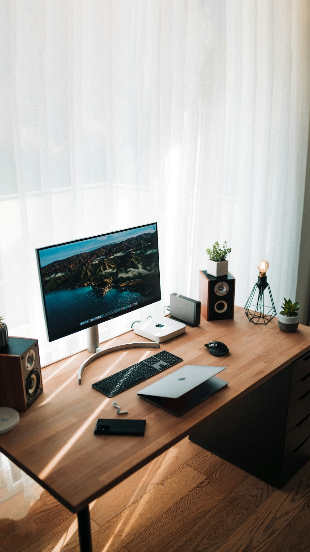 Silberner Imac auf braunem Holzschreibtisch