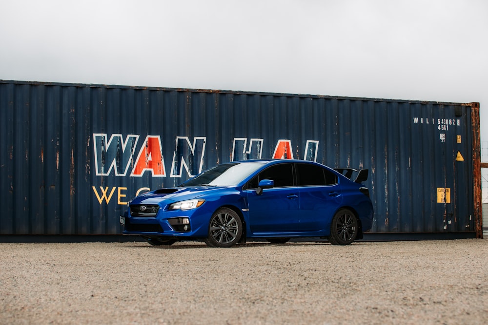 blue bmw m 3 coupe parked beside blue and white wall