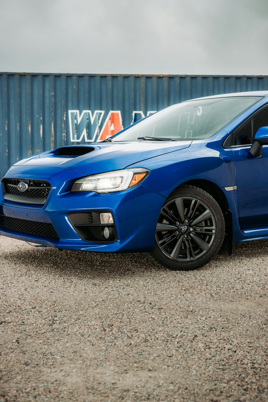 blue honda car parked near white building