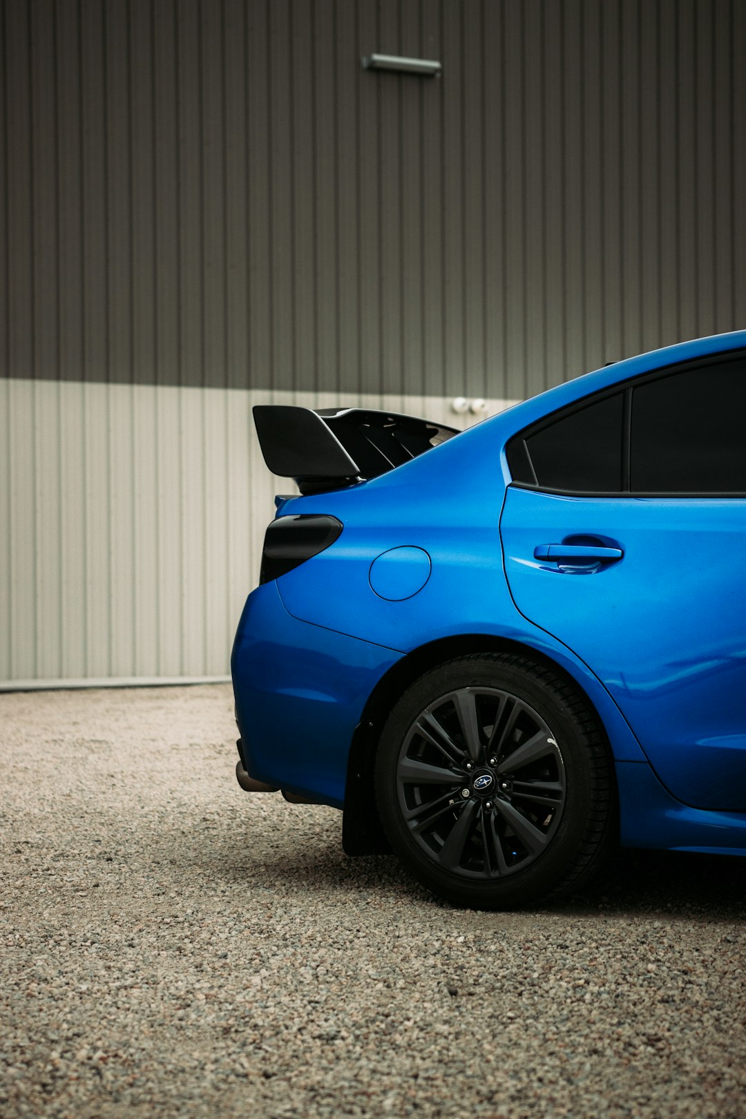 blue car parked near white roll up door