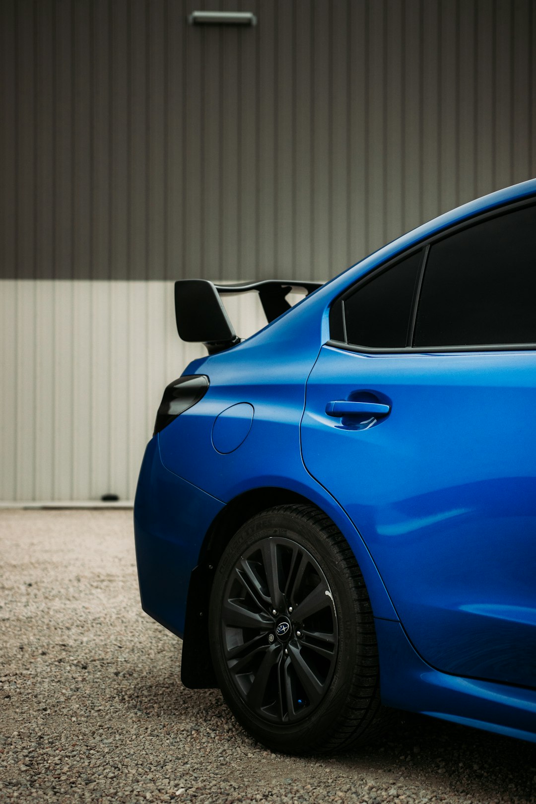 blue car parked near white wall