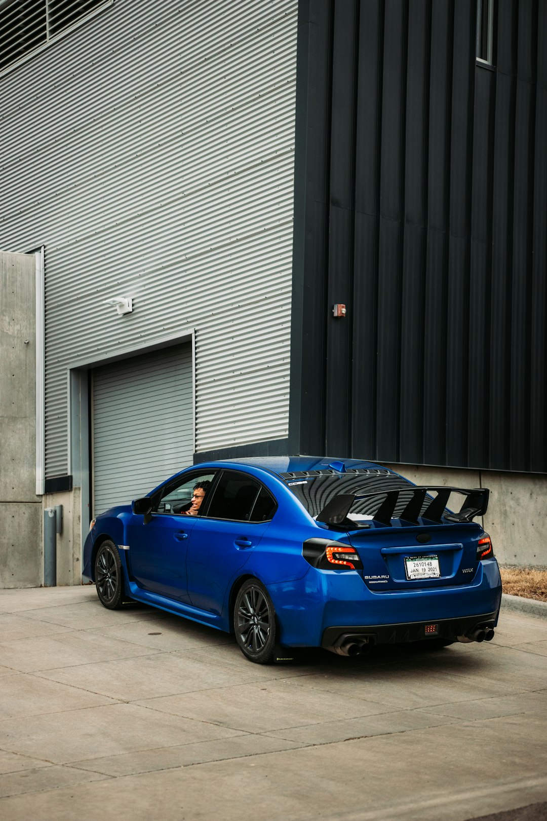 blue audi r 8 parked near black roll up door