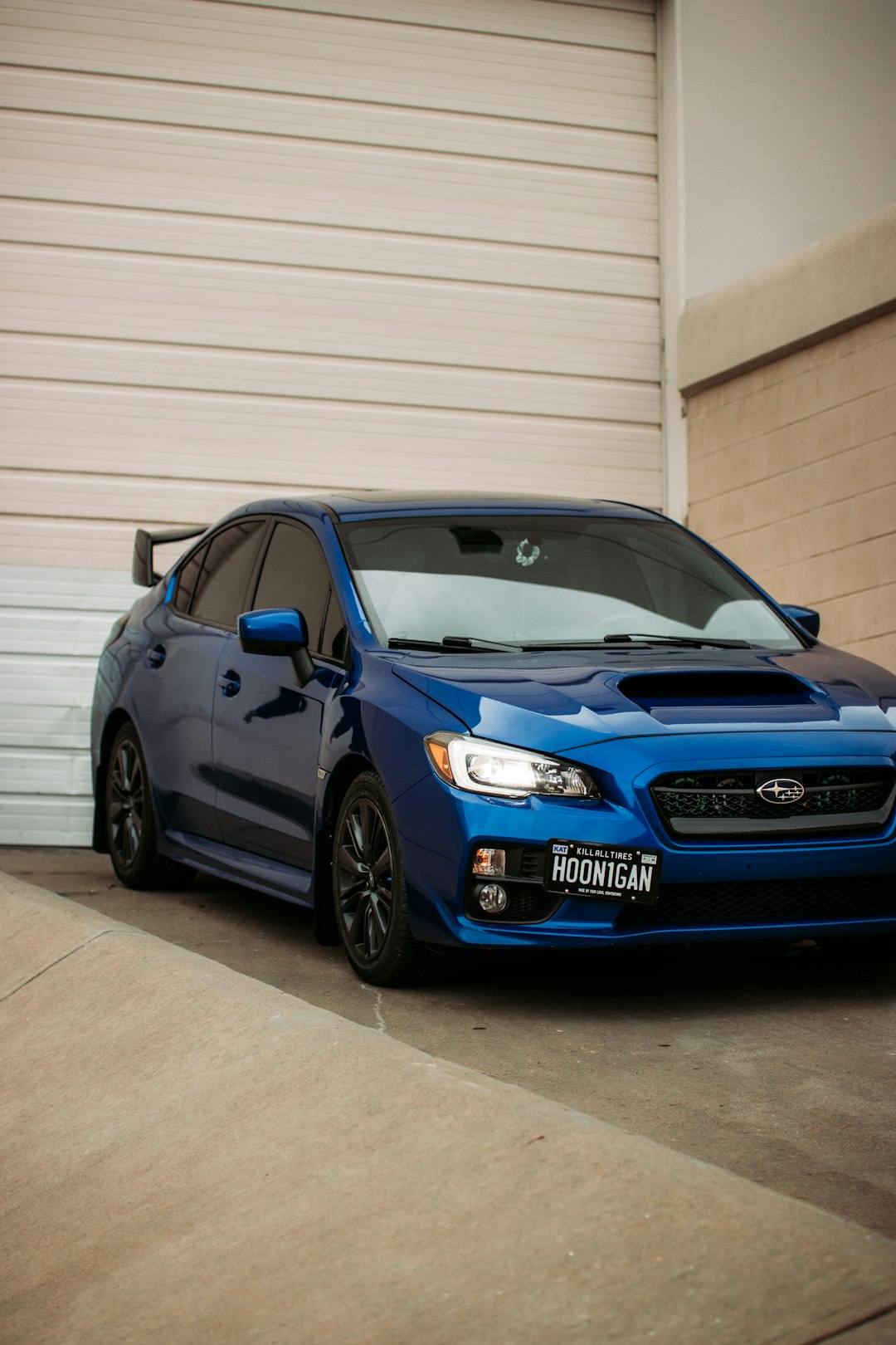 blue honda sedan parked beside white garage door