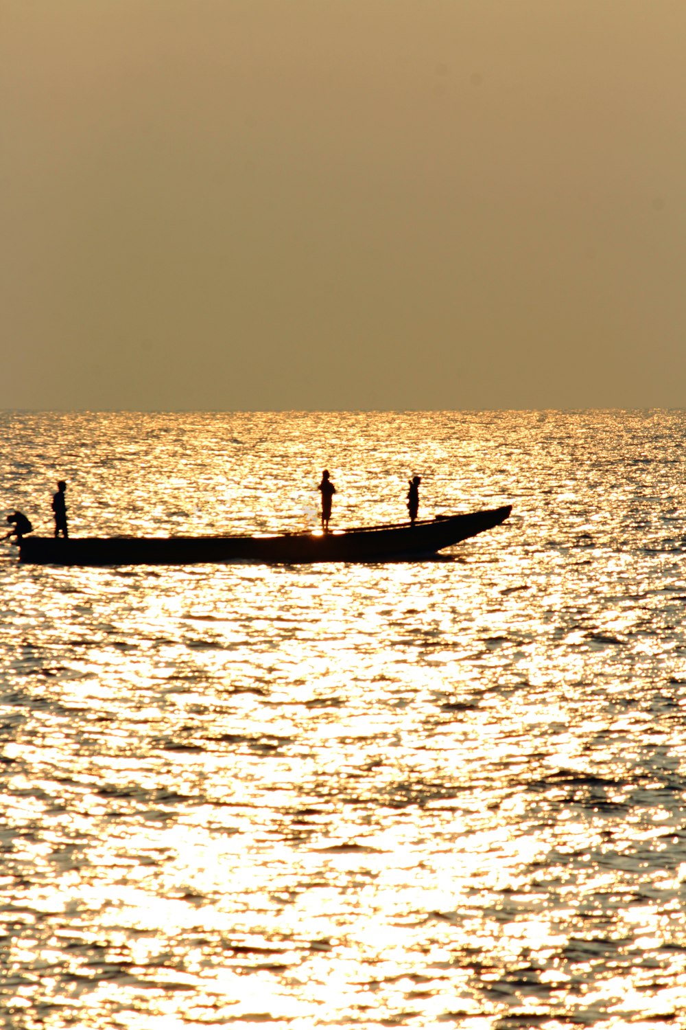 silhouette of 2 people riding on boat during sunset