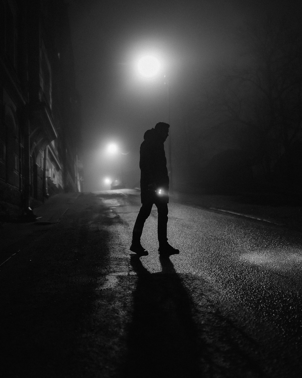 silhouette of person walking on road during night time