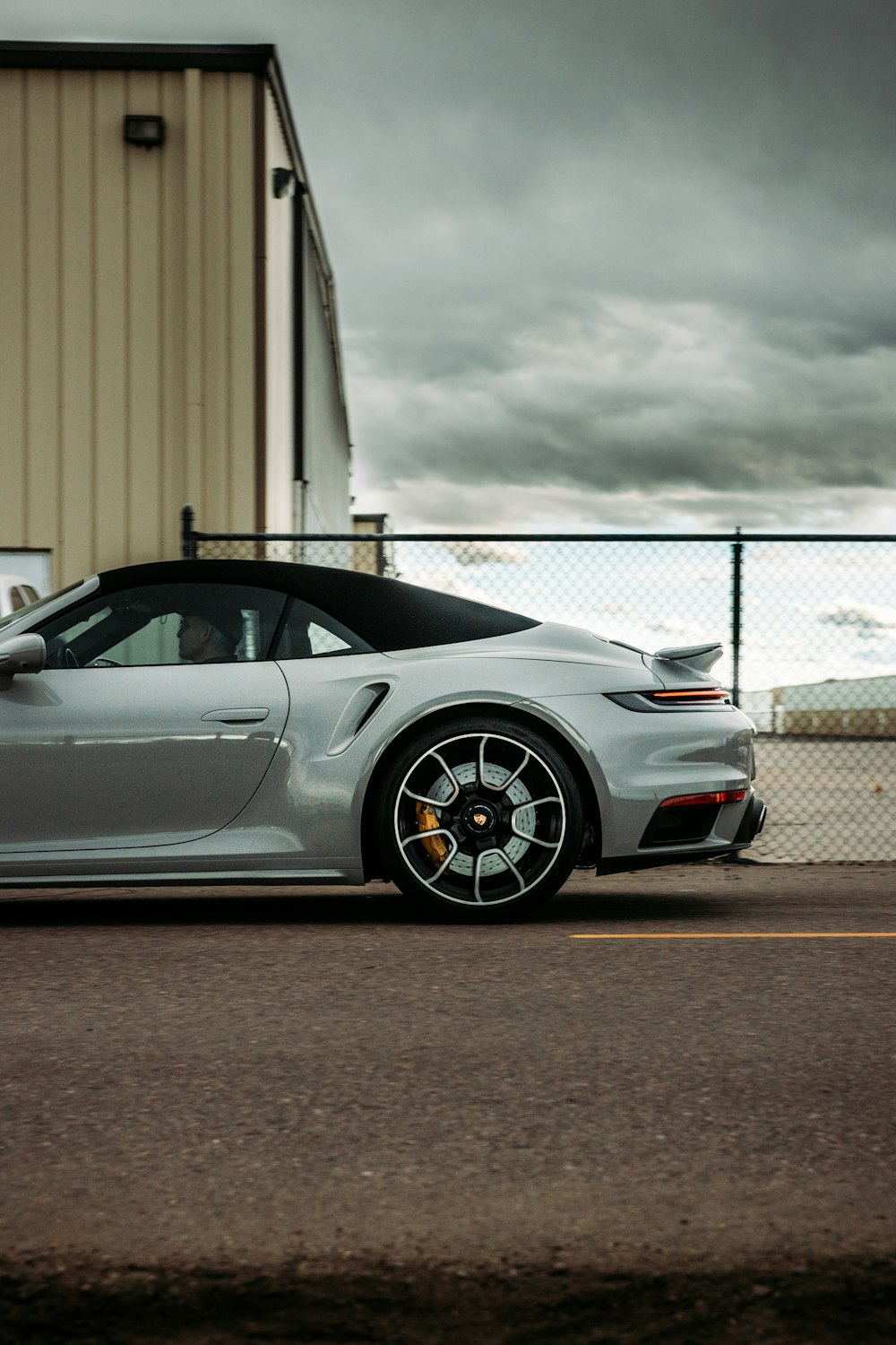 Porsche 911 blanco aparcado cerca de un edificio blanco