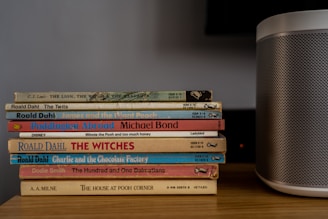 stack of books on brown wooden table