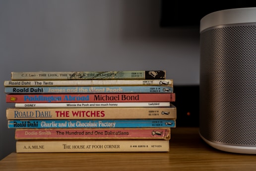 stack of books on brown wooden table