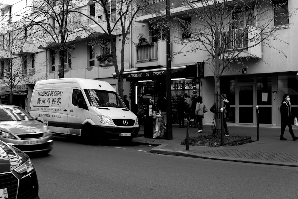 grayscale photo of white van on road