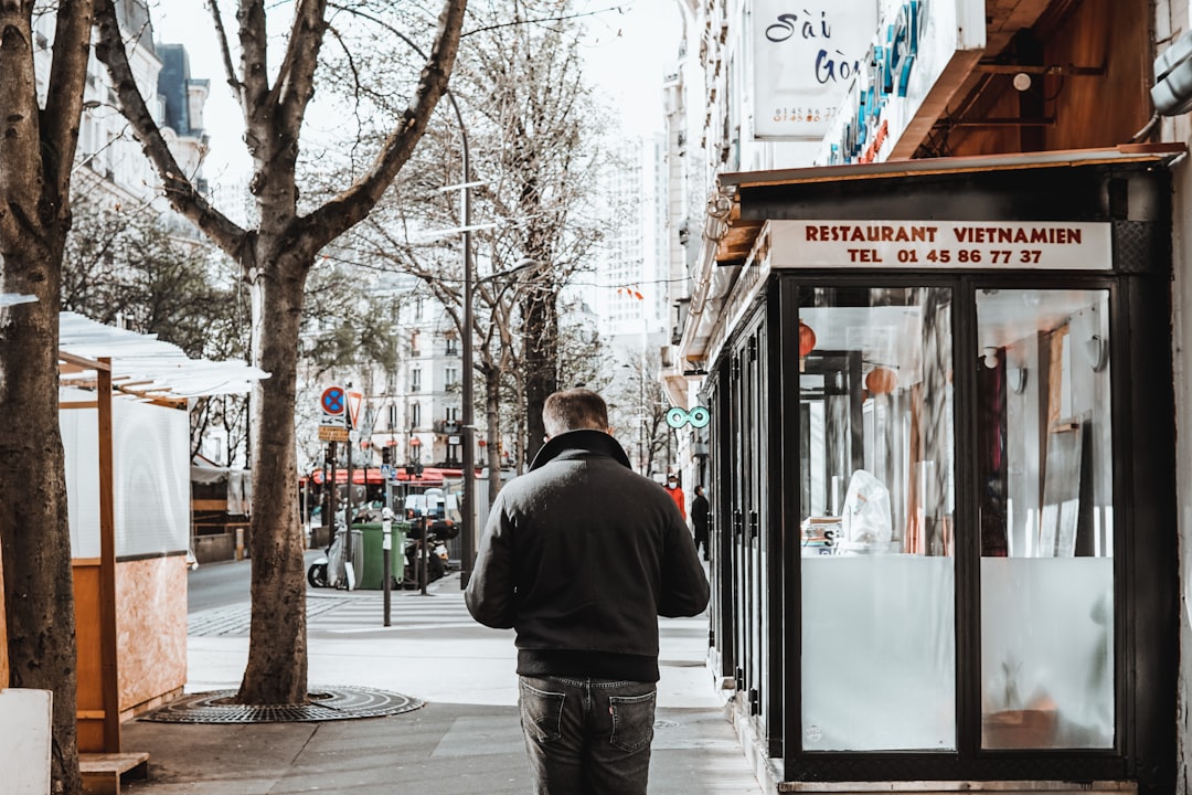 man in black jacket standing near glass window