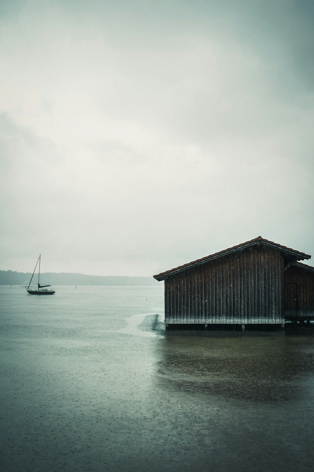 Maison en bois brun sur plan d’eau pendant la journée